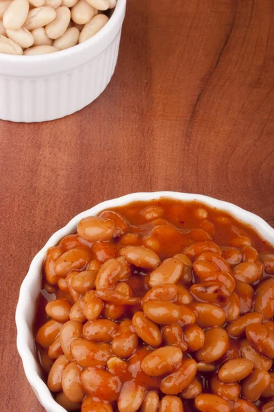赤いソース添え白セラミック皿に白い缶詰の豆 — ストック写真