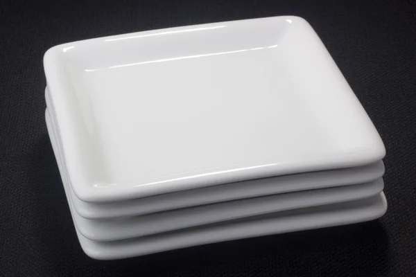 デザートの皿 黒の背景上の白い正方形セラミック板 — ストック写真