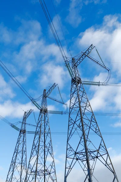 電力線と青い曇り空を背景に電気のパイロン — ストック写真