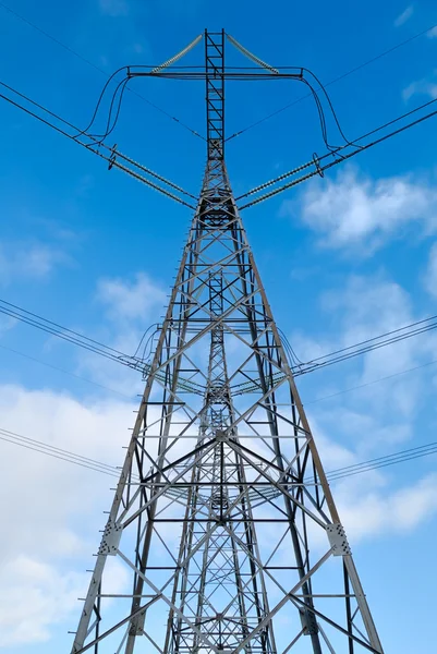 電力線と青い曇り空を背景に電気のパイロン — ストック写真
