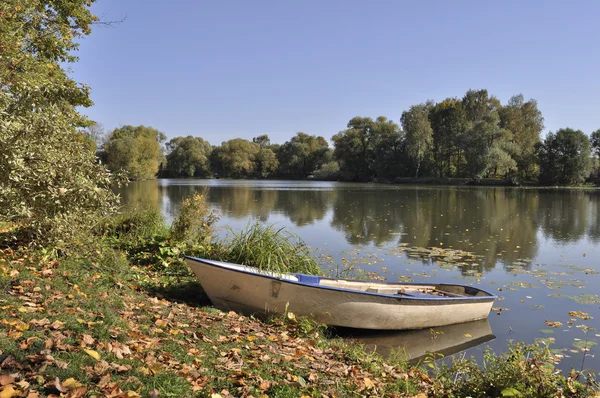 Sonbahar aylarında göl kıyısında tekne — Stok fotoğraf