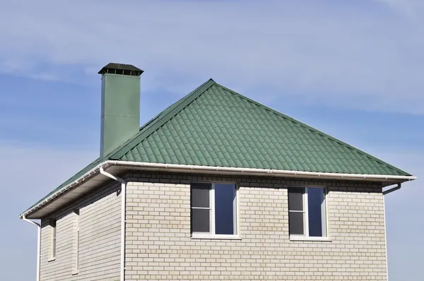 Зелений дах білого цегляного будинку — стокове фото