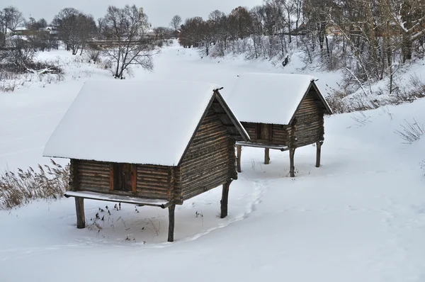 Stodoły na palach nad brzegiem w zimie — Zdjęcie stockowe