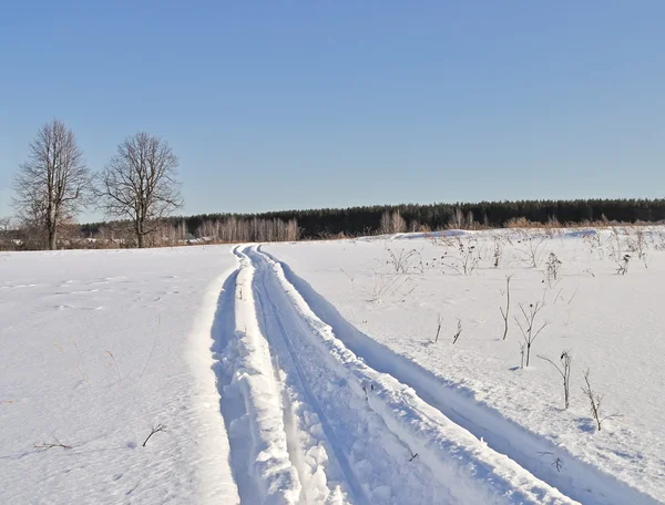 Spoor van sneeuwscooter op de rand van het dorp — Stockfoto