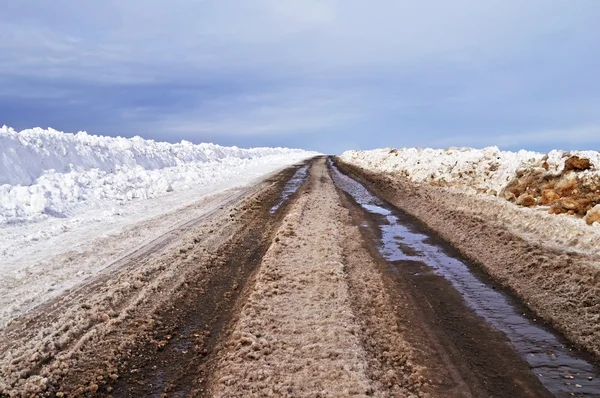 早春の汚れた雪でアスファルト道路 — ストック写真