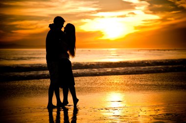 Engaged couple at the beach clipart