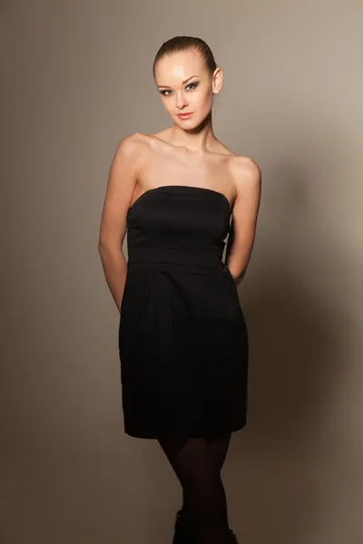 Elegante chica joven en vestido pequeño negro — Foto de Stock