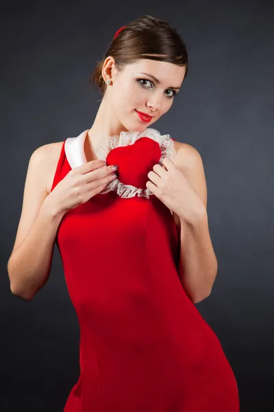 Μελαχρινή κοπέλα με κόκκινο φόρεμα που κρατά την καρδιά — Φωτογραφία Αρχείου