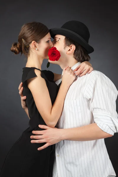 Пара поцелуев и держа розу — стоковое фото
