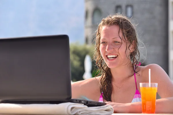 Kobieta jest za pomocą laptopa z basenem w pobliżu hotel — Zdjęcie stockowe