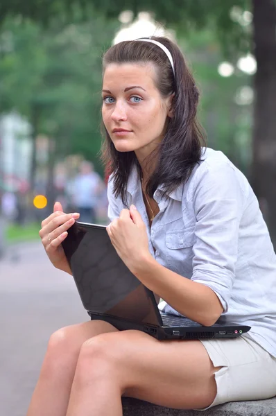 Woman with laptop in city park — Stock Photo, Image
