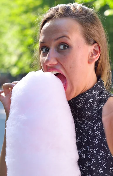 Mujer divertida comiendo hilo de azúcar en el parque —  Fotos de Stock