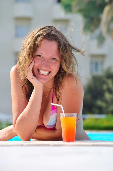 Mujer sonriente en la piscina con cóctel —  Fotos de Stock