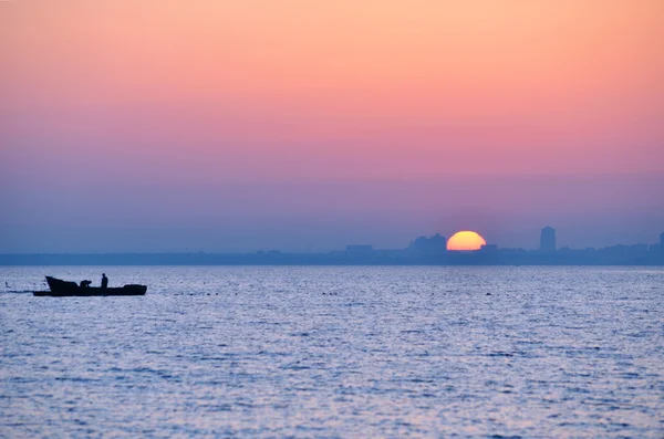 Stadens siluett från havet vid soluppgången — Stockfoto