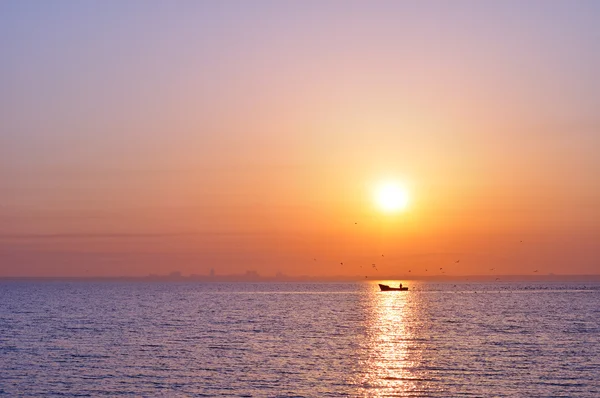 Силуэт города от моря на восходе солнца — стоковое фото