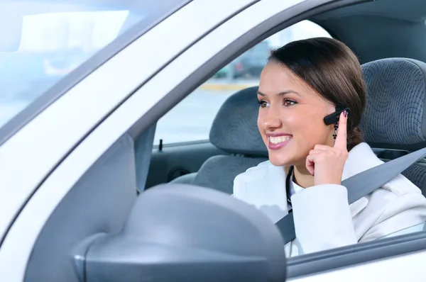 美丽的女人安全地谈论使用 bluetoo 车电话 — 图库照片