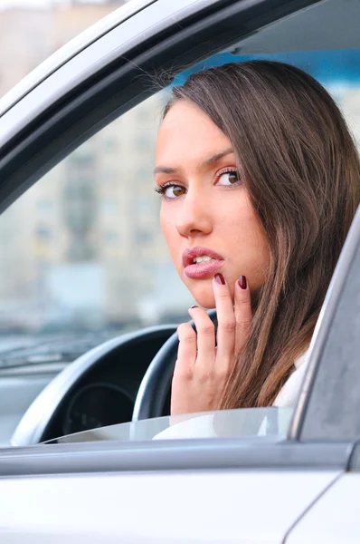 Smyslná mladá žena se dívá na kameru z auta — Stock fotografie
