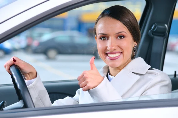 Mutlu kadın bir arabanın başparmağını gösteriyor. — Stok fotoğraf