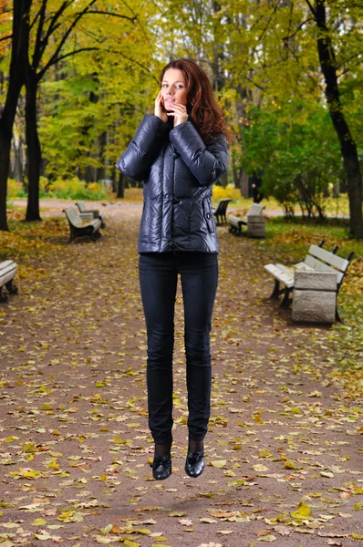 Mujer que se eleva sobre un camino en el parque de otoño — Foto de Stock