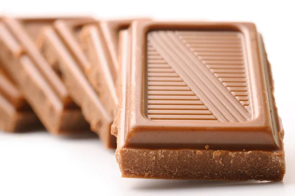 Barras de chocolate em linha isoladas em branco — Fotografia de Stock