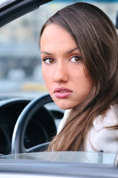 관능적 인 젊은 여성 이 자동차에서 카메라를 보고 있습니다. — 스톡 사진