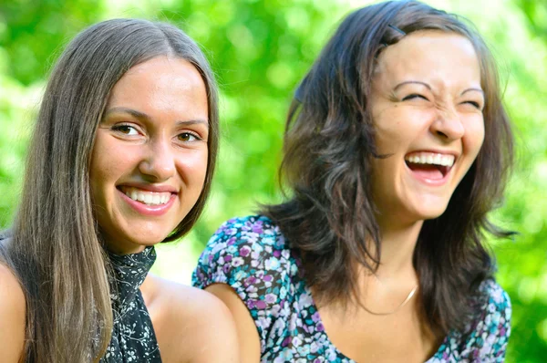 Twee vrouwelijke vrienden is lachen in zonnige park — Stockfoto