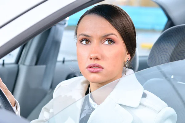 Vrouw in een auto kijkt omhoog — Stockfoto