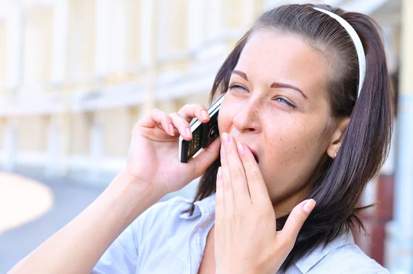 Woman is talking phone and yawning — Stock Photo, Image