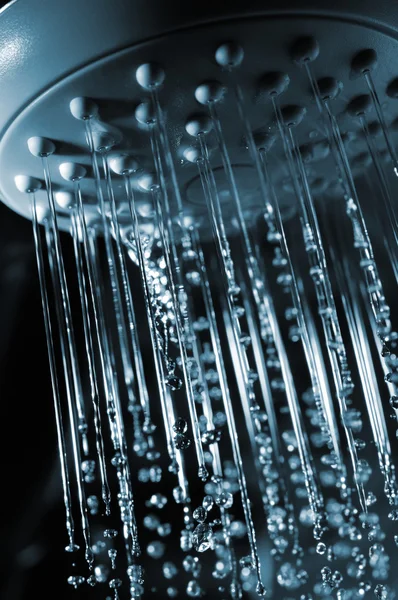 stock image Closeup view of water flowing out of shower in dark