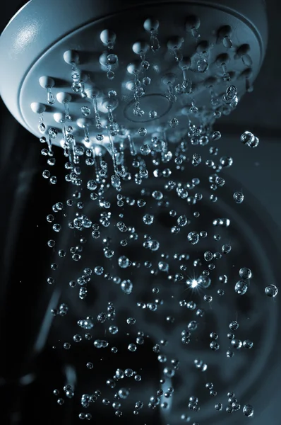 stock image Closeup view of water flowing out of shower in dark