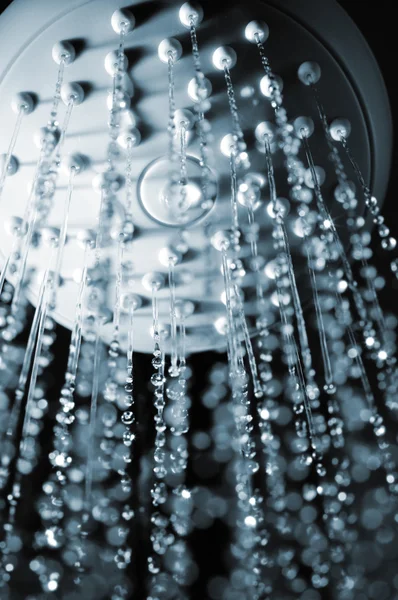 stock image Closeup view of water flowing out of shower in dark