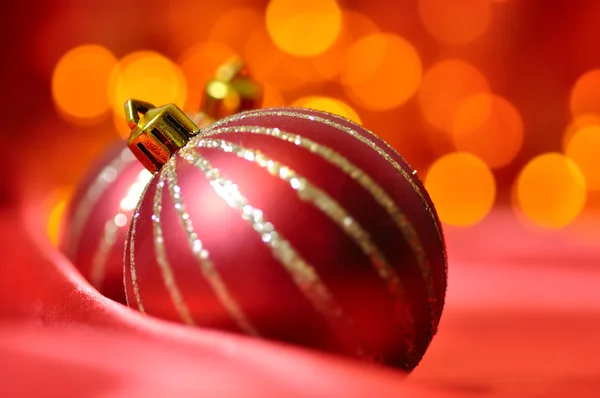 圣诞装饰球上反对模糊灯上的红色丝绸 — 图库照片