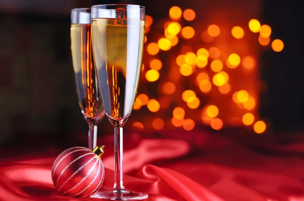 Dos copas de champán sobre seda roja — Foto de Stock