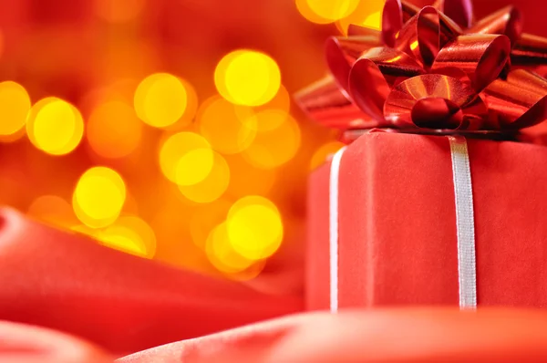Closeup of a red gift box with blurred lights on background — Stock Photo, Image