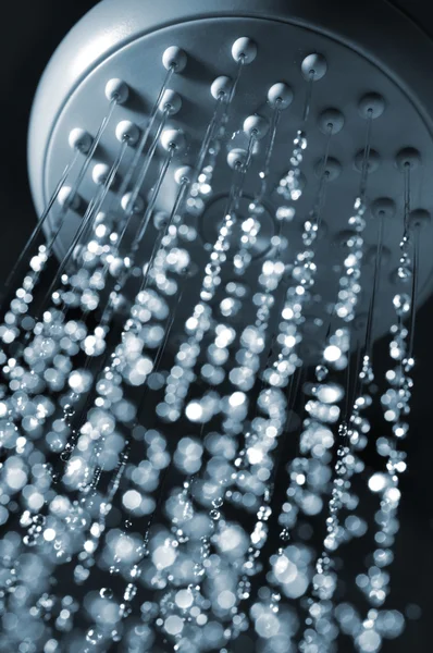 stock image Closeup view of water flowing out of shower in dark