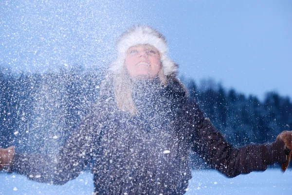 Kvinna kastar snö på vinter kväll — Stockfoto