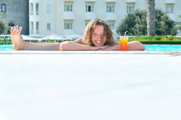 Lustige Frau zeigt ihr Bein aus dem Pool — Stockfoto