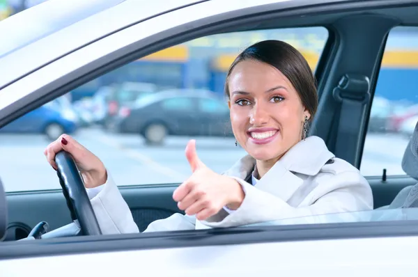 Mulher feliz está mostrando um polegar de um carro — Fotografia de Stock