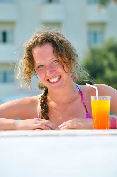 Привлекательная женщина улыбается от бассейна на курорте — стоковое фото