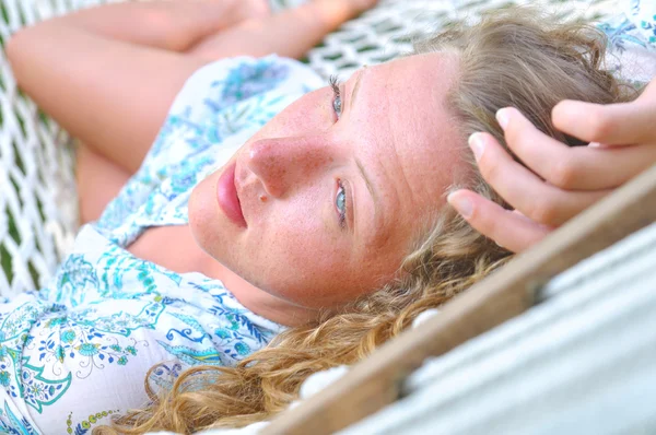 Сексуальная женщина лежит в гамаке и смотрит в сторону — стоковое фото