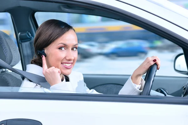 Piękna kobieta kierowca rozmawia spokojnie telefon w samochodzie przy użyciu — Zdjęcie stockowe