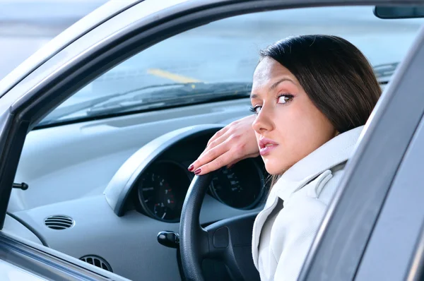 Όμορφη αισθησιακό γυναίκα βάζει το κεφάλι της στο τιμόνι και looki — Φωτογραφία Αρχείου