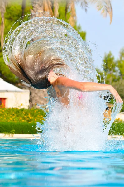 Mujer delgada está saltando y arrojando el pelo mojado de nuevo en la caca de natación — Foto de Stock