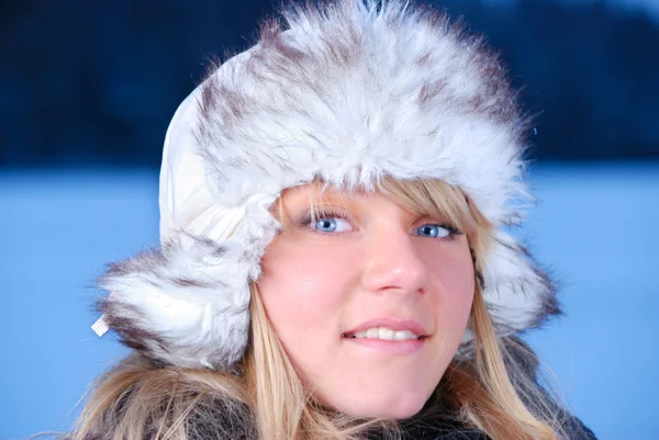 Beautiful young woman in furry hat at winter evening Stock Photo