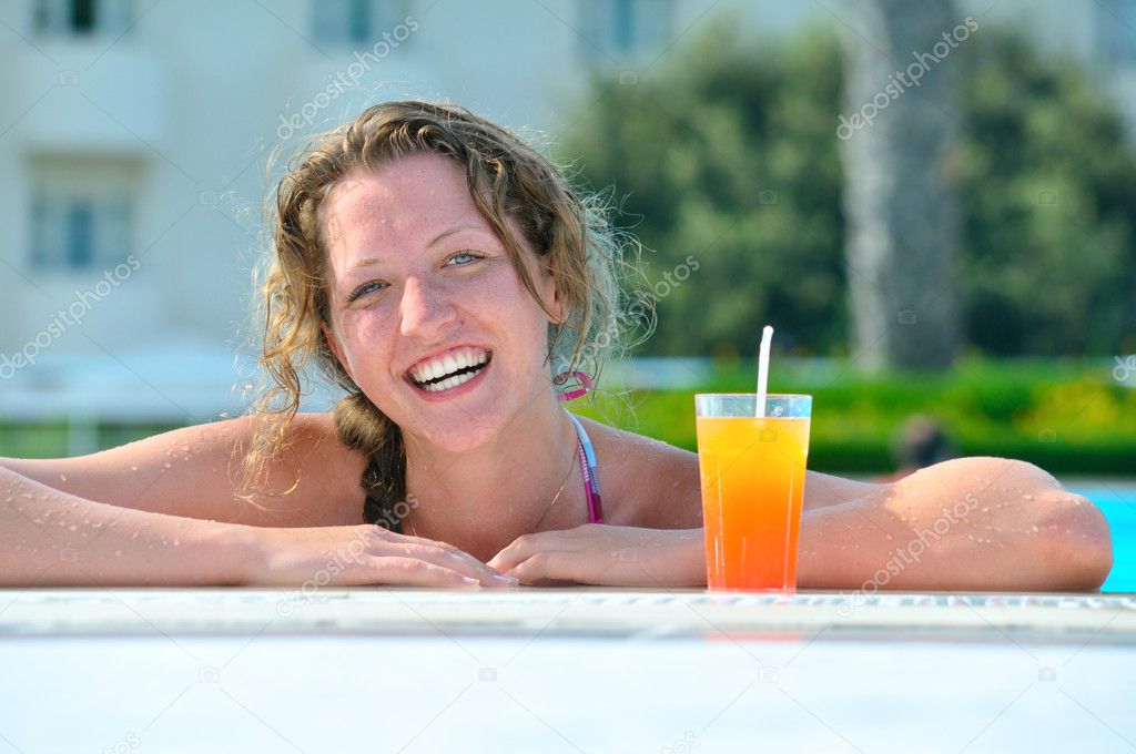 Attractive woman is smiling from swimming pool in resort