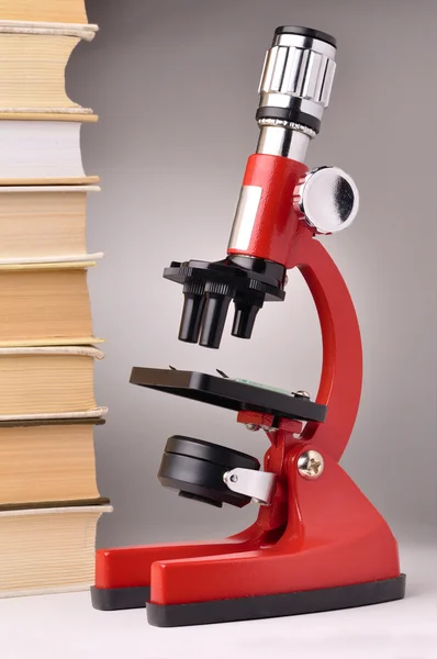Βιβλία και το μικροσκόπιο, επιστημονικό ή εκπαιδευτικό έννοια — Φωτογραφία Αρχείου