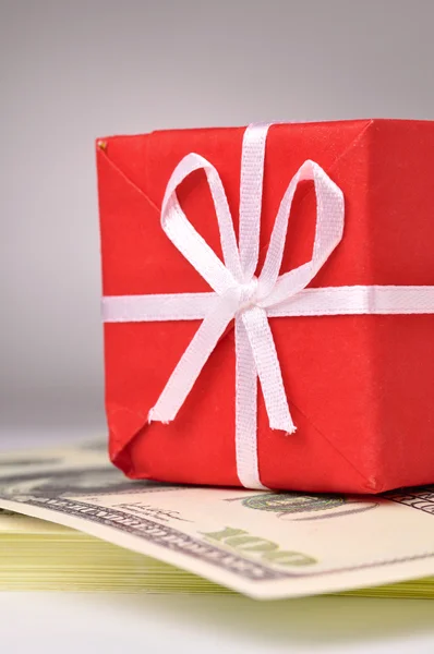Caixa de presente vermelho no bacth de notas de dólares — Fotografia de Stock