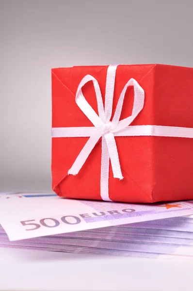 Scatola regalo rossa sulla pancetta delle banconote in euro — Foto Stock