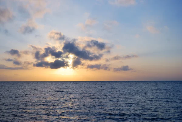 Blauwe oceaan van de fantastische zonsopgang bij bewolkt weer — Stockfoto