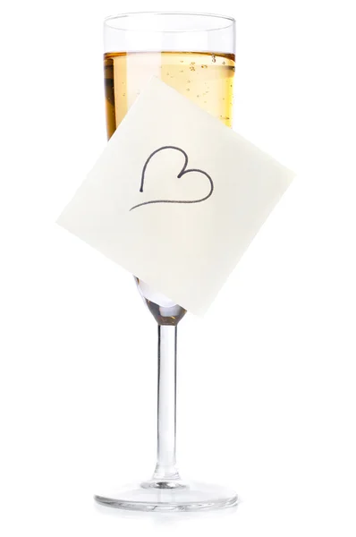 Ποτήρι σαμπάνιας με καρδιά στην κολλώδη σημείωση που απομονώνονται σε λευκό — Φωτογραφία Αρχείου